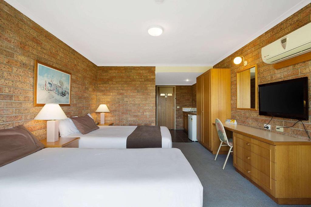 Room with a double and single bed, desk and smart TV