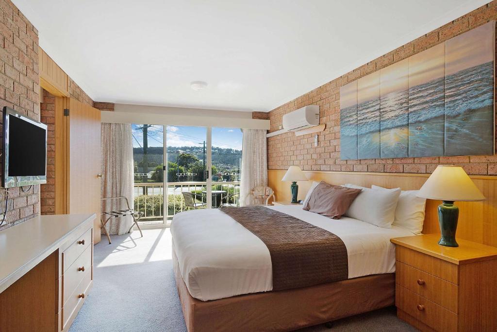 King Room with Spa Bath — king bed, coastal artwork and balcony view