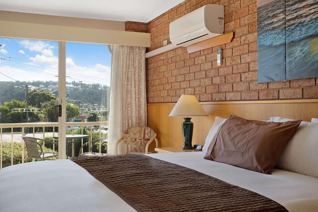 King room with brick feature wall and town views from the balcony